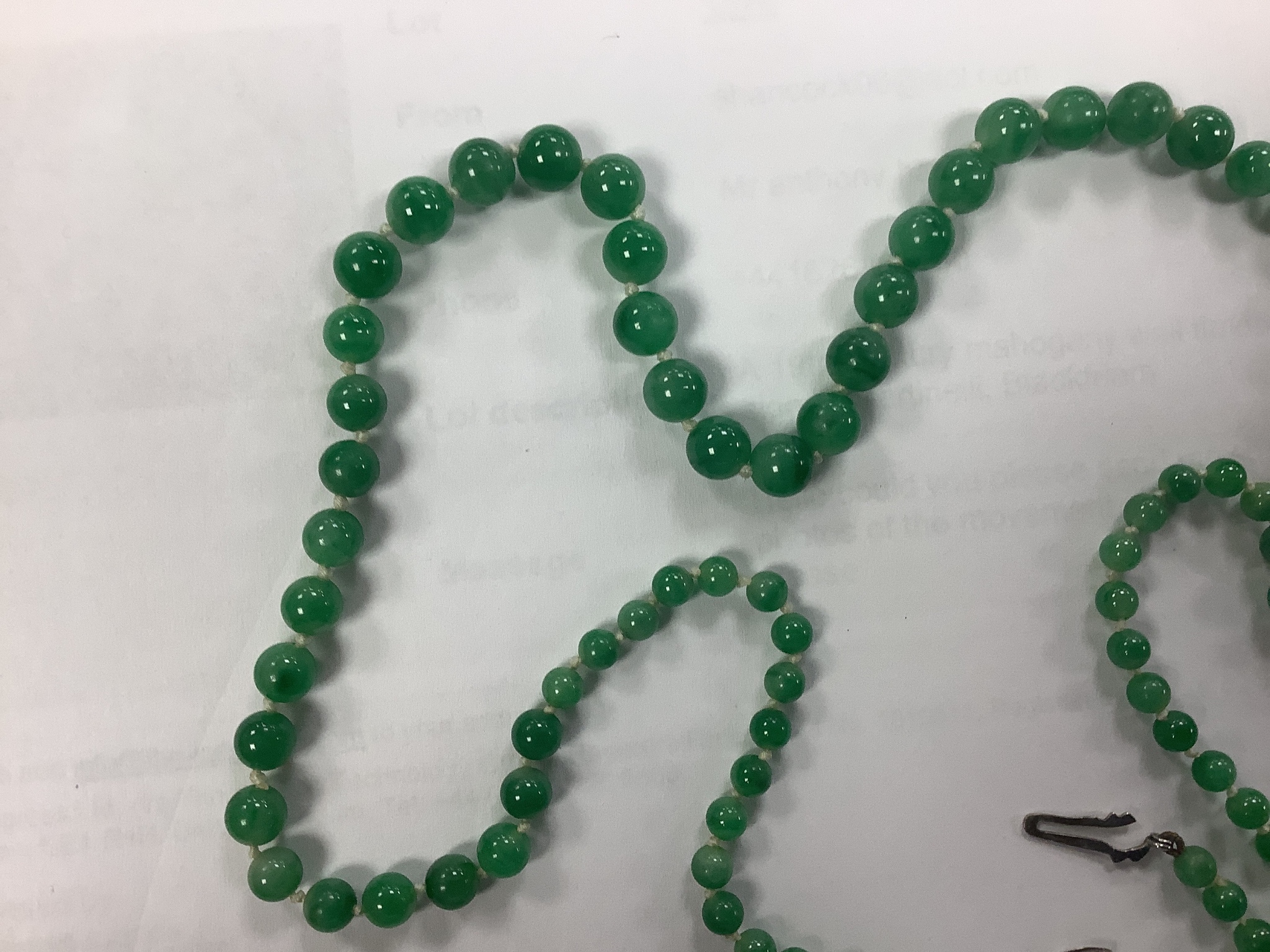 A graduated jade bead necklace with diamond set clasp stamped 9ct, 50cm